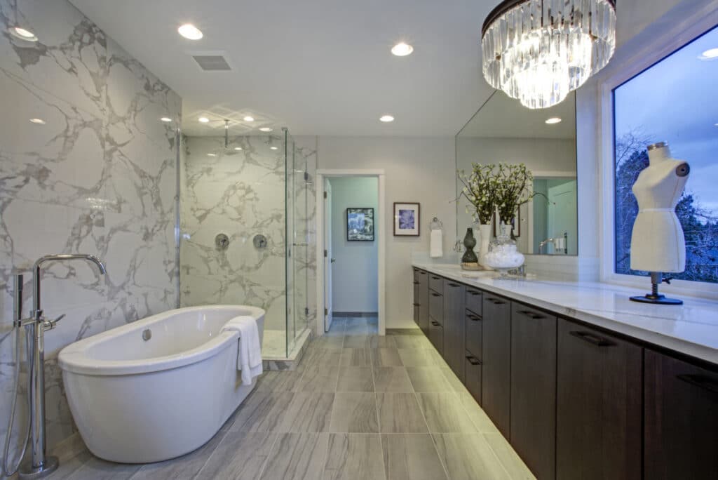 Elegant bathroom remodeling project with Brown vanities, white countertop, tub and shower