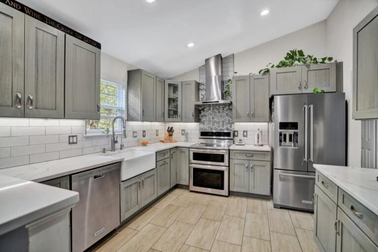 Farmhouse style kitchen project in Stafford VA with gray shaker cabinets, white countertops, and beige tiles flooring