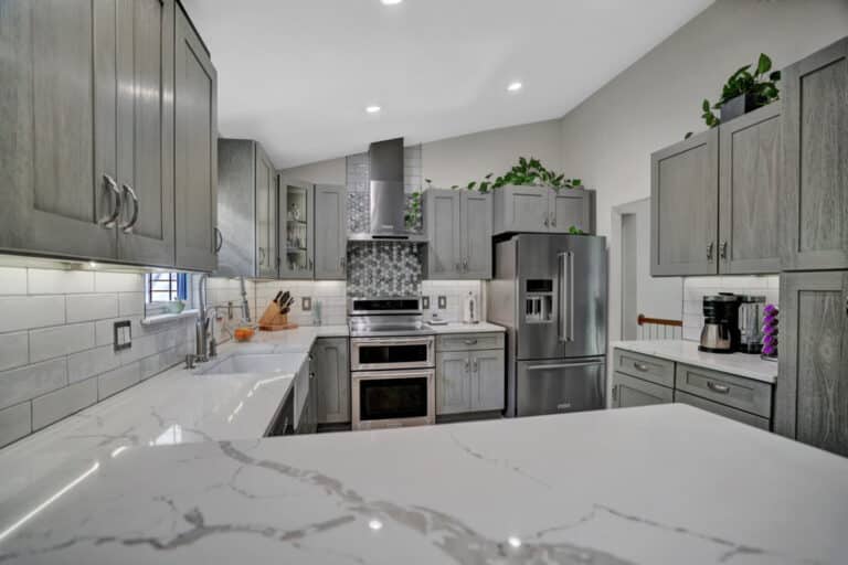 Farmhouse style kitchen project in Stafford VA with gray shaker cabinets, white countertops, and beige tiles flooring