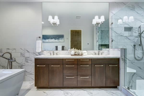 Elegant bathroom with tub, brown vanity, and shower