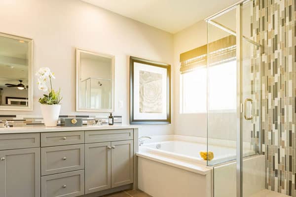 Bathroom with grey shaker vanity, and tub