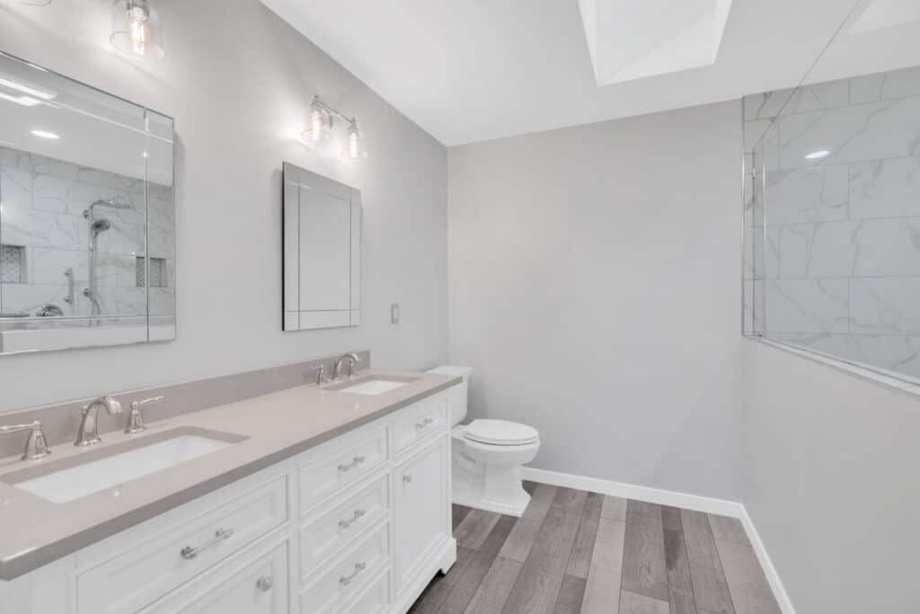 Spacious light gray bathroom project in Fredericksburg va with white vanity, and toilet