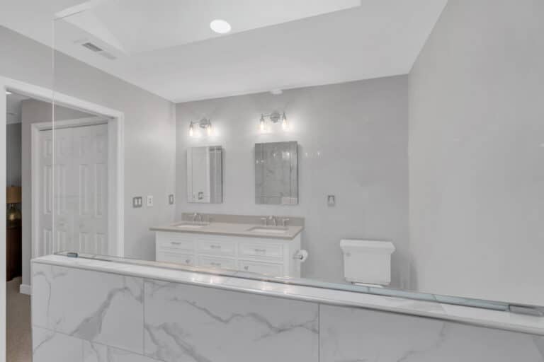 Spacious light gray bathroom project in Fredericksburg va with white vanity, and toilet