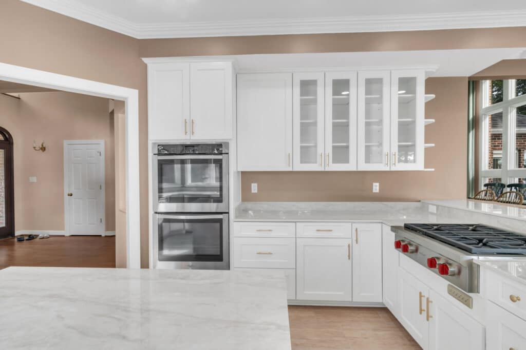 Brown kitchen project in locust grove va with white cabinets with glass door on wall cabinets, and white countertop