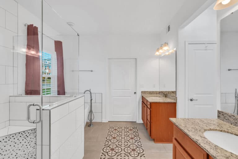 Spacious bathroom project in waldorf md with 2 brown vanities, tub, and shower