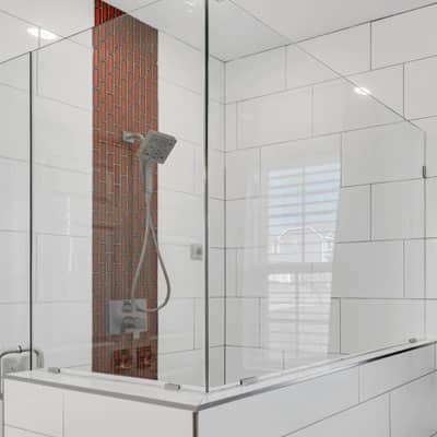 Shower with glass and white tiles surround