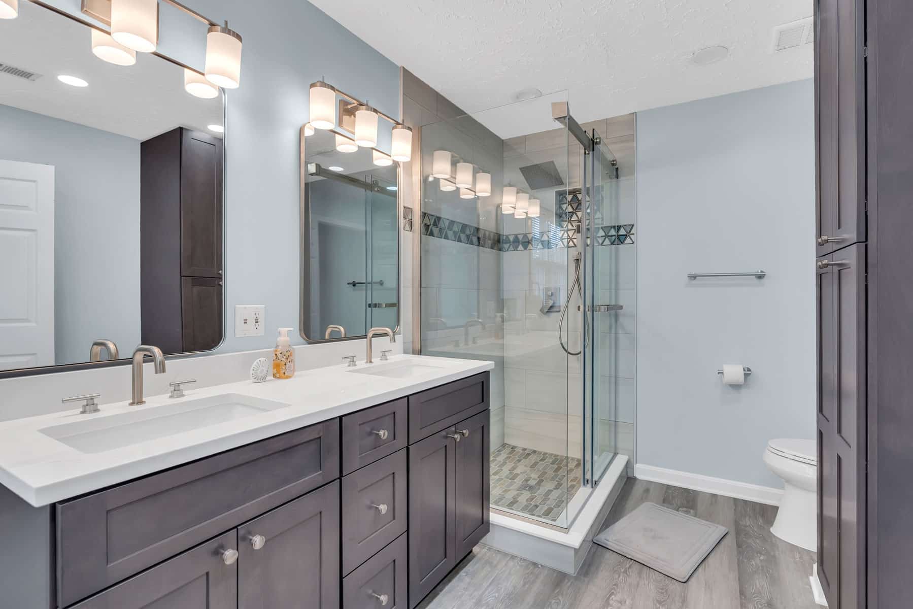 Elegant bathroom project in waldorf with gray shaker vanity, shower, and toilet