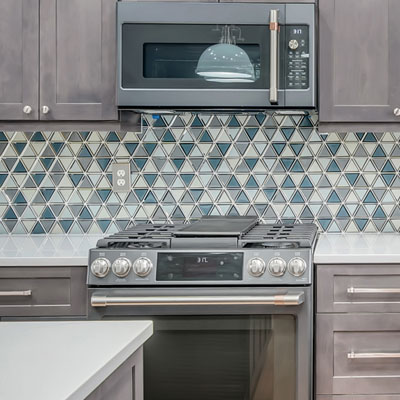Patterned backsplash on kitchen with gray shaker cabinets