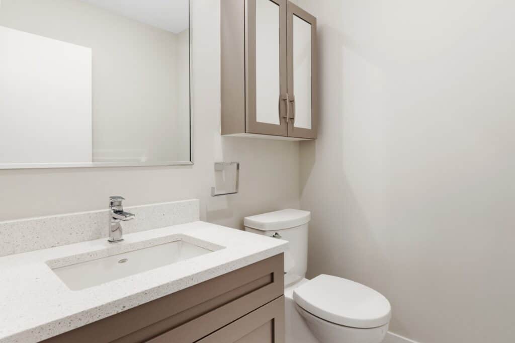 Small bathroom with brown vanities and medicine cabinet