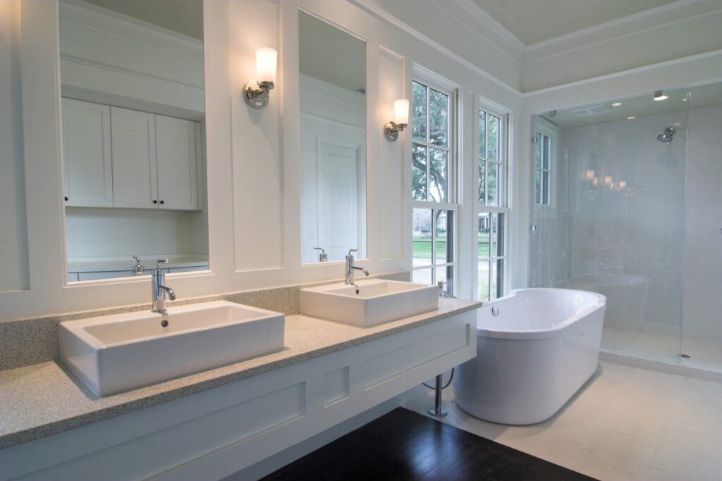 White bathroom with double-sink vanity, tub and shower
