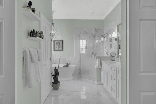 Luxurious bathroom with sage green paint, white doors and cabinets