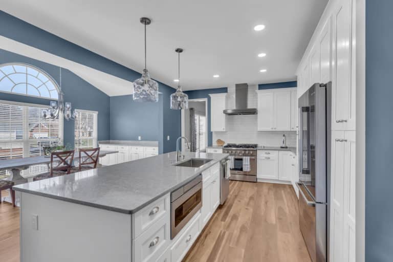 Elegant kitchen with white cabinets, gray countertop