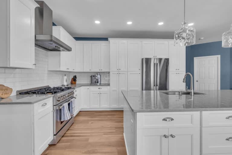 White kitchen cabinets and wood flooring