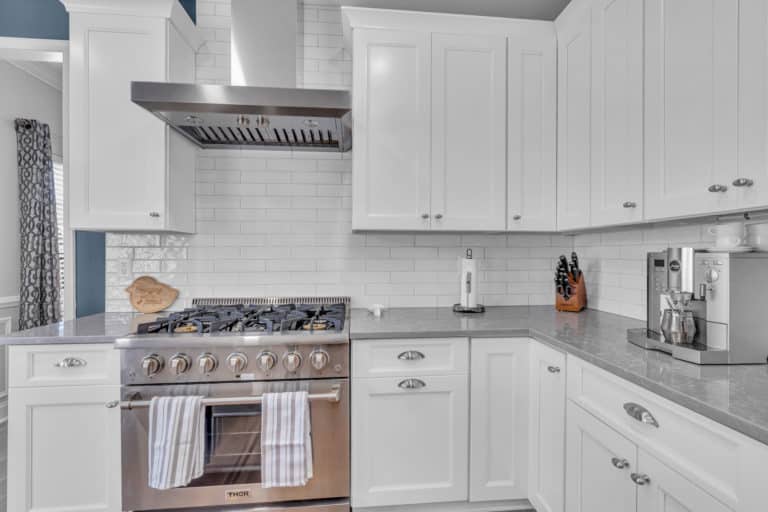 Elegant kitchen with white cabinets, gray countertop