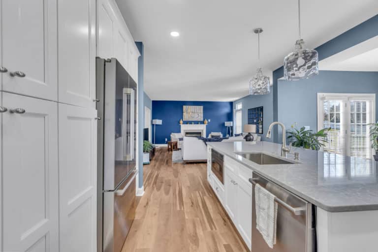 Elegant kitchen with white cabinets, gray countertop and wood flooring