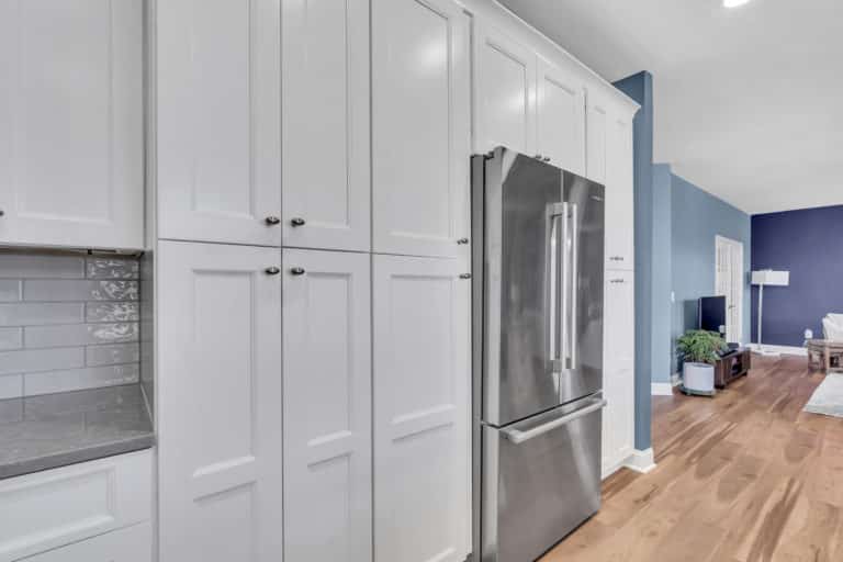 Elegant kitchen with white cabinets, gray countertop