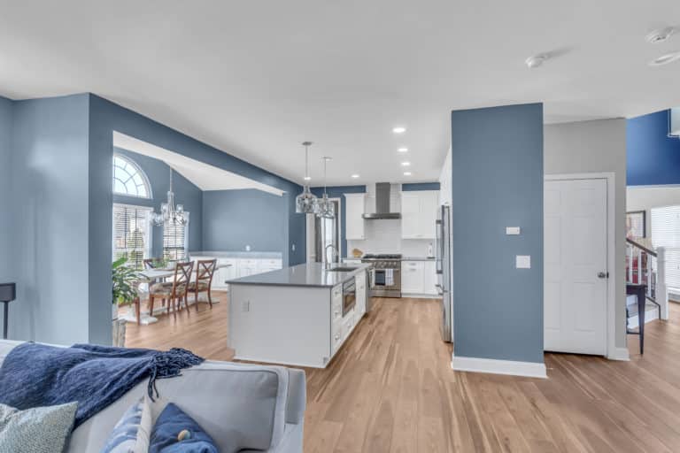 Elegant Kitchen and Bathroom Project in Fredericksburg with white cabinets, gray countertop, wood flooring and blue walls