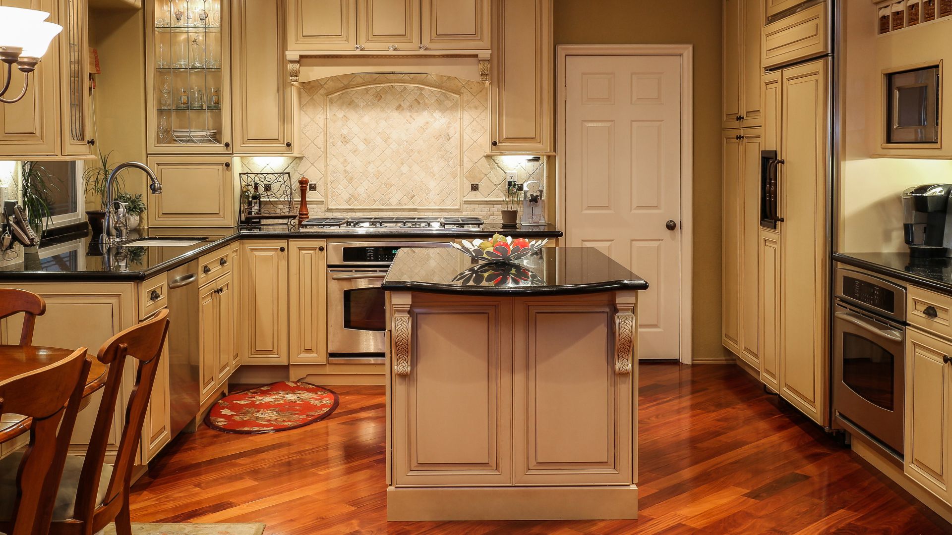 Traditional style kitchen with beige cabinets and wood flooring