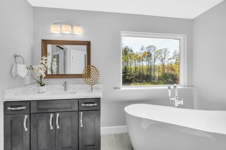 Elegant bathroom with gray vanity and tub