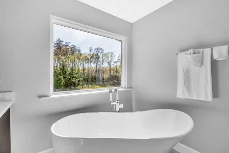 Light gray bathroom with tub and silver hardware