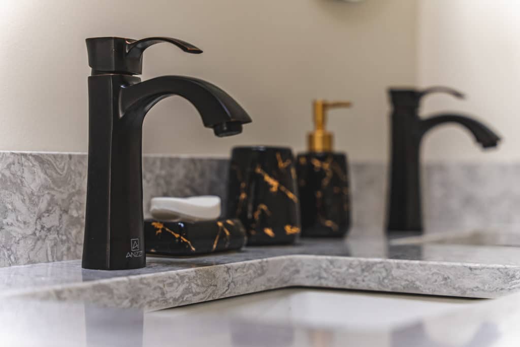 Black faucet and sink on gray countertop