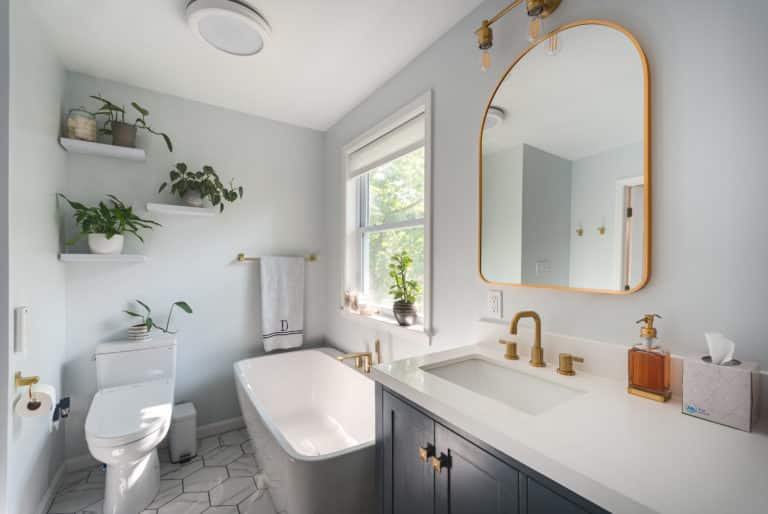 White Bathroom Remodeling Project in Stafford VA with navy vanity, tub, and textured flooring