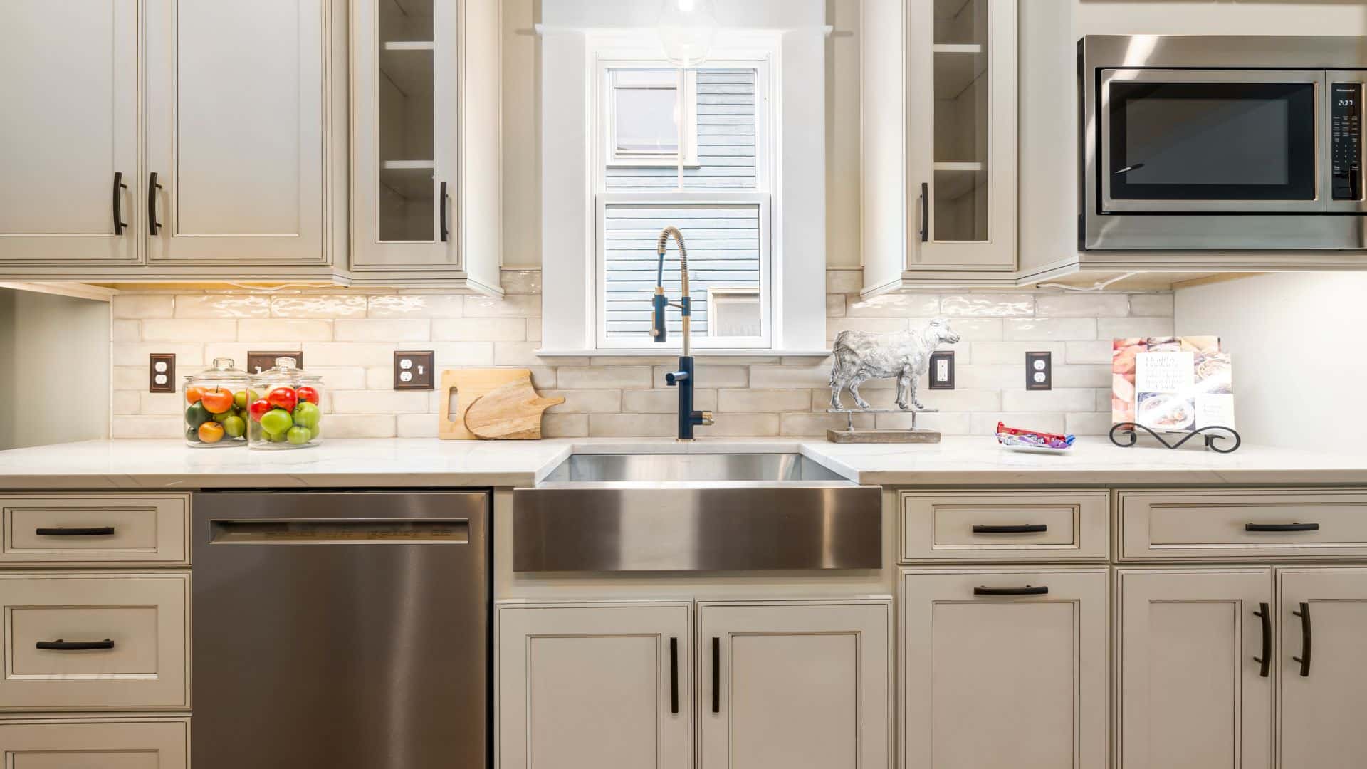 Off-white kitchen cabinets with countertops and tile backsplash