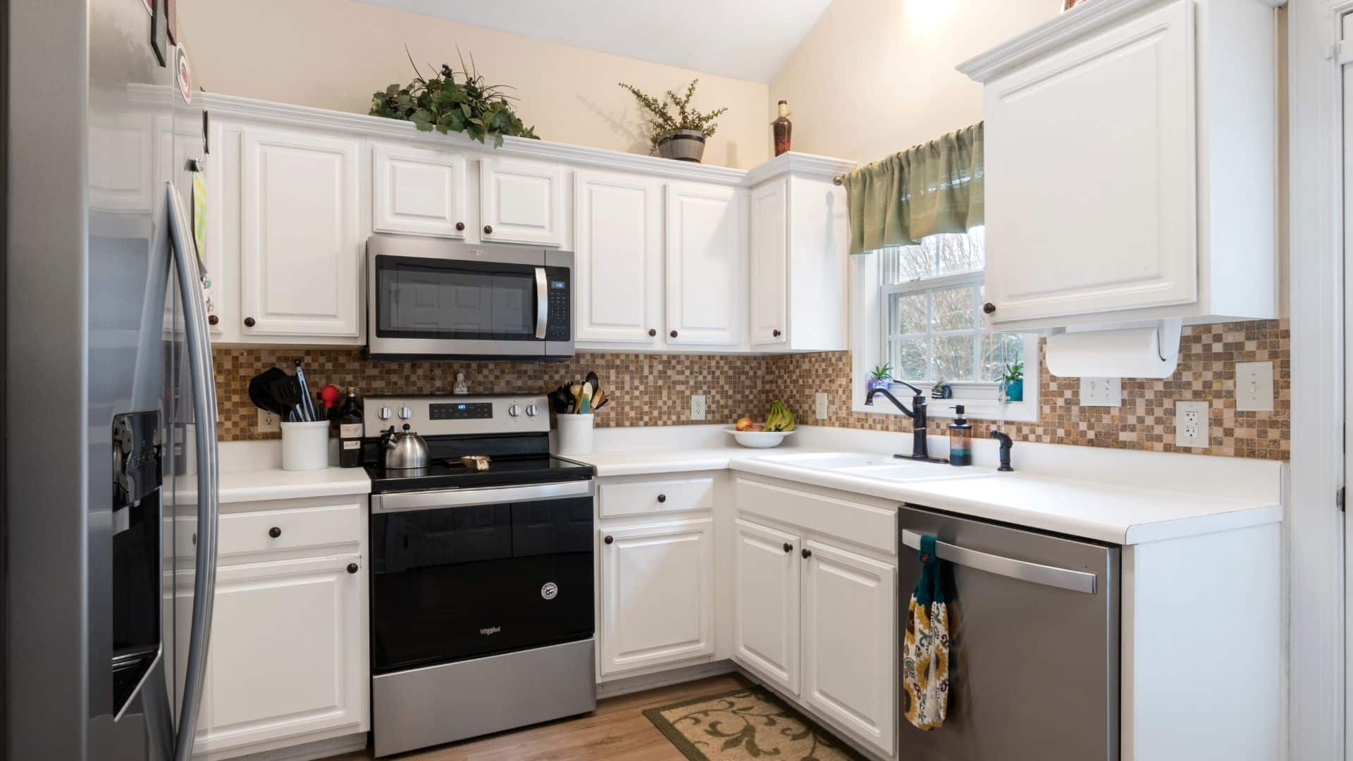 Small L-type kitchen with white cabinets and countertops