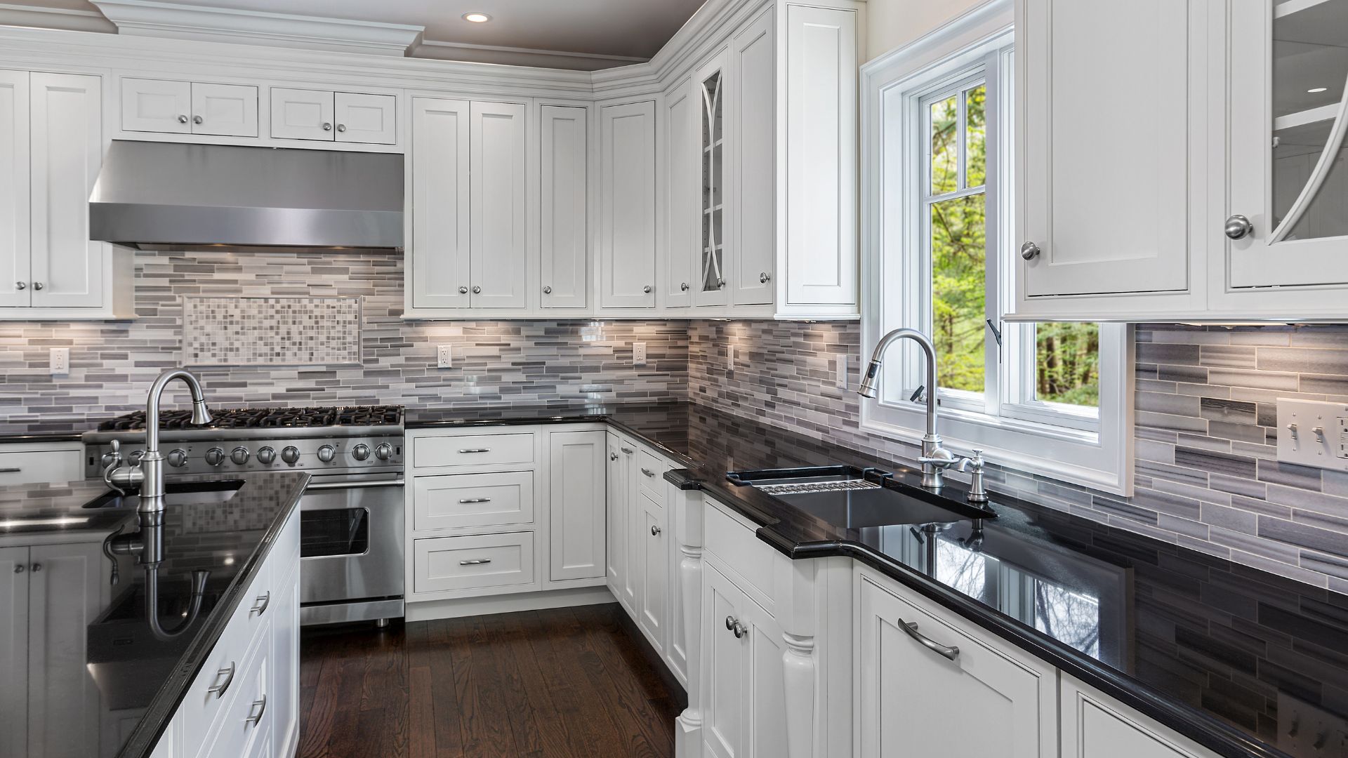 L Type kitchen with white shaker cabinets and black countertops
