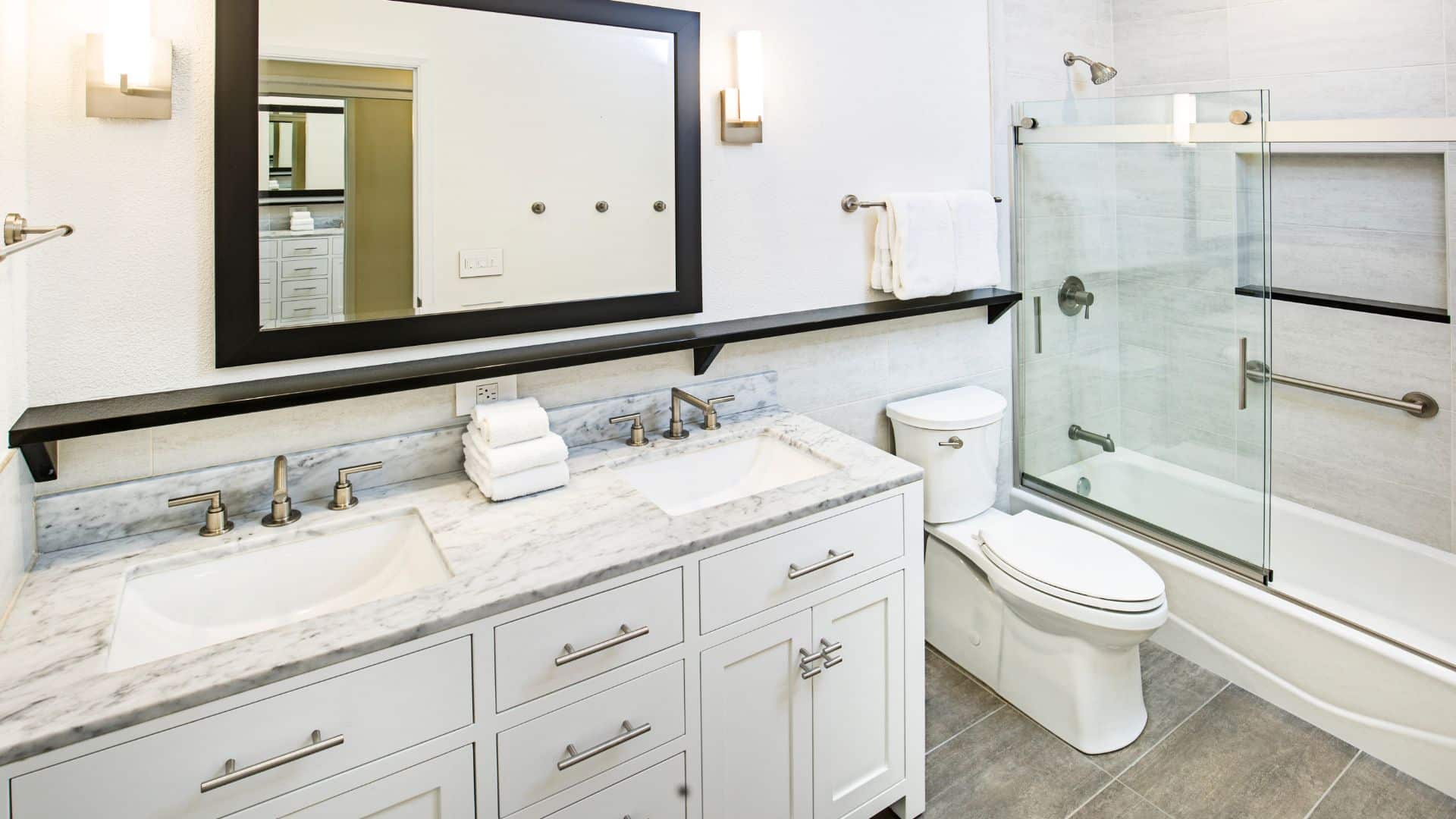 Elegant bathroom style with white cabinets, toilet, and tub-shower combination