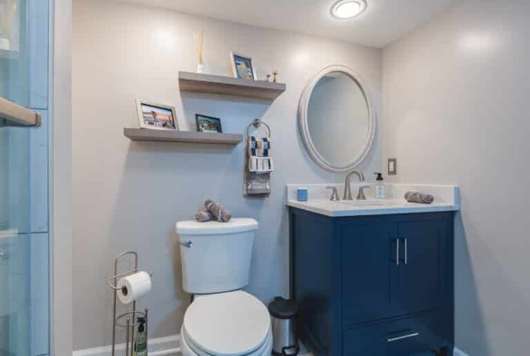 Modern bathroom style with navy vanity, toilet