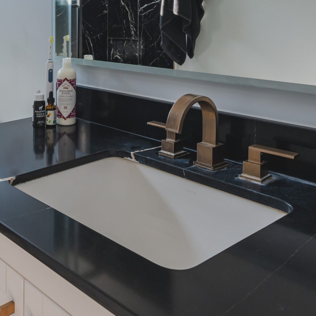 Black countertop, bronze sink, faucet