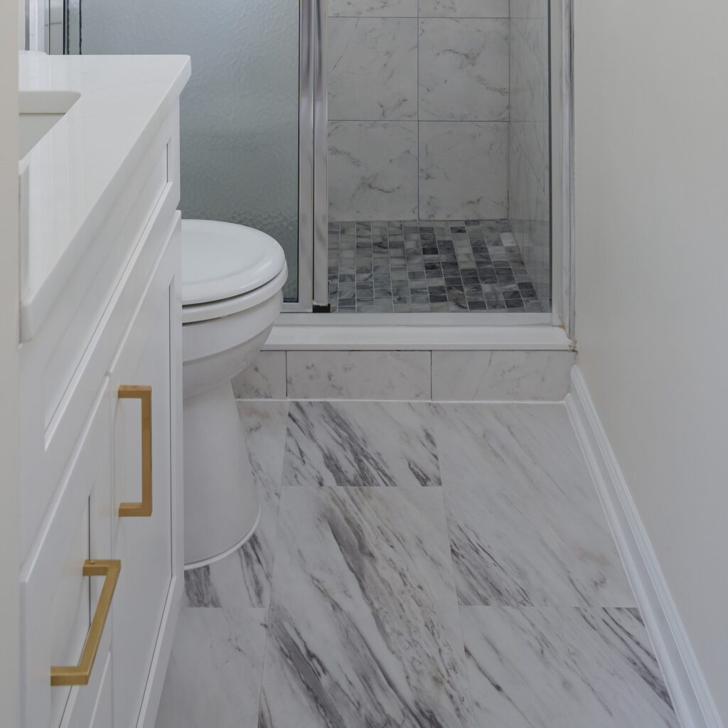 Bathroom Remodel In Nokesville, VA white vanity, tiles flooring, toilet, and shower