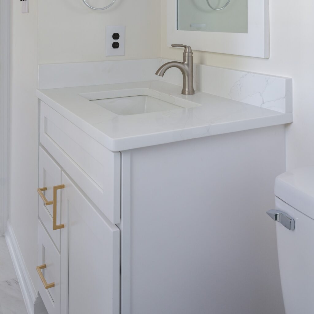 White vanity with silver faucet, gold handles