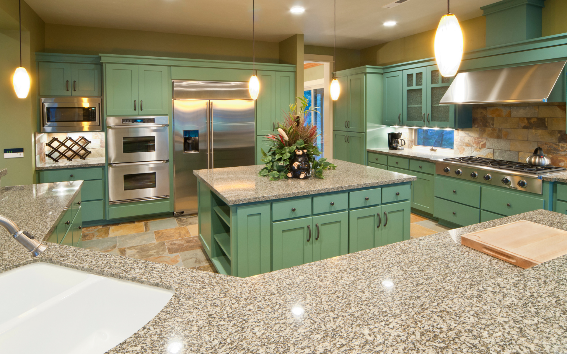 Spacious kitchen with green shaker cabinets, and granite countertop