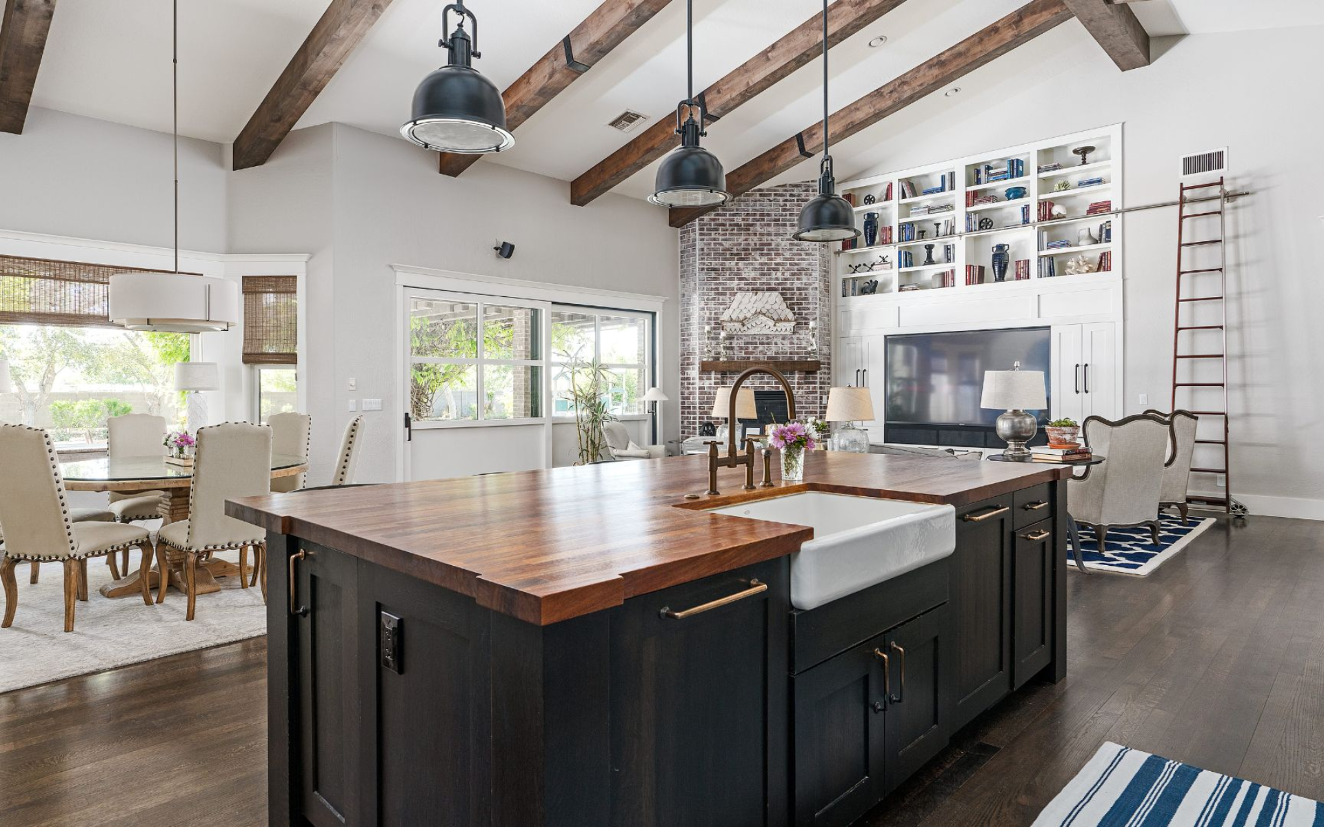 Farmhouse style kitchen with black cabinets and wood countertop