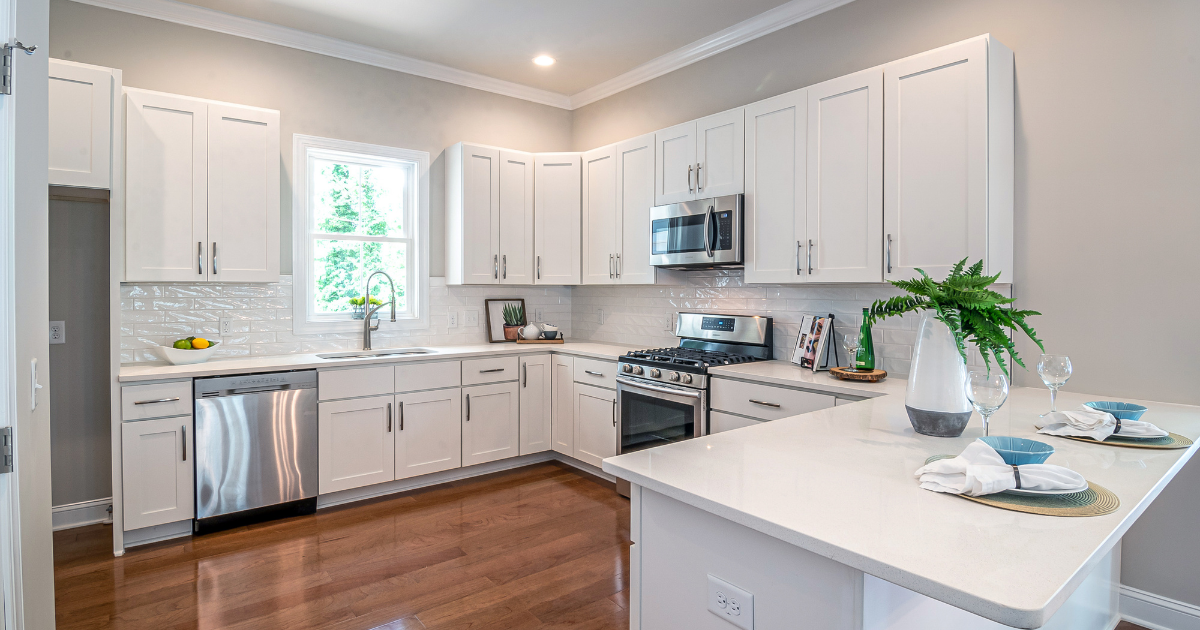 White kitchen using shaker cabinets, and brown wood flooring