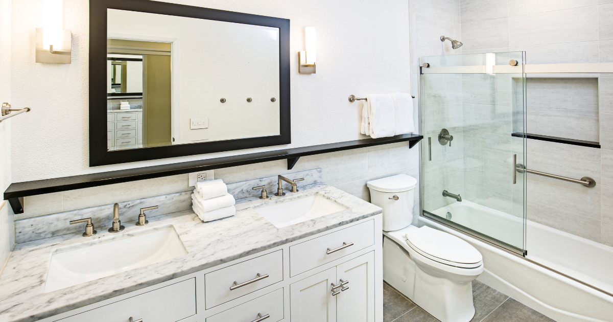 White small bathroom with double-sink vanity, toilet, and tub-shower