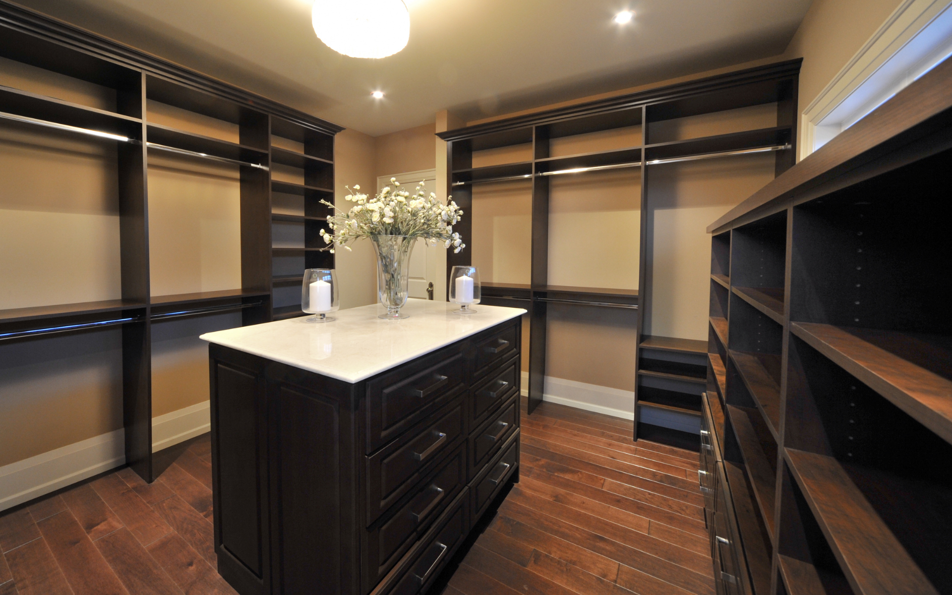 Small space custom closet with dark brown center island cabinet